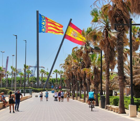 Espagne : le gouvernement augmente le salaire minimum et réduit la semaine de travail Un groupe de personnes marche le long d'une route à côté de palmiers à Valence en Espagne.