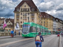 La semaine de 4 jours en Suisse – bientôt possible ? Un vélo traverse un pont tandis qu'un tram vient de l'autre côté.