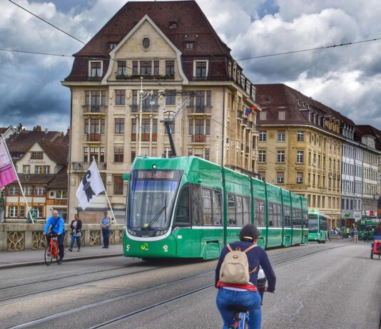 La semaine de 4 jours en Suisse – bientôt possible ? Un vélo traverse un pont tandis qu'un tram vient de l'autre côté.