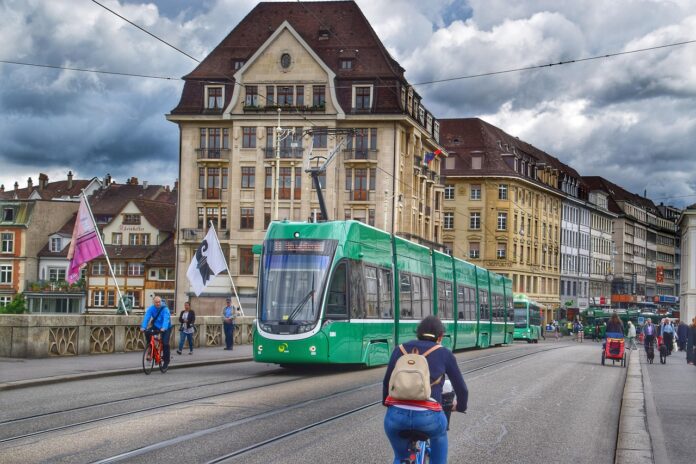 Un vélo traverse un pont tandis qu'un tram vient de l'autre côté.