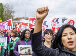 1er mai : la solidarité plutôt que la haine 1er mai à Genève, une jeune femme lève son poing