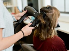 Attaque du Centre : le salaire minimum bientôt contourné Une coiffeuse sèche les cheveux d'une cliente avec une brosse ronde.