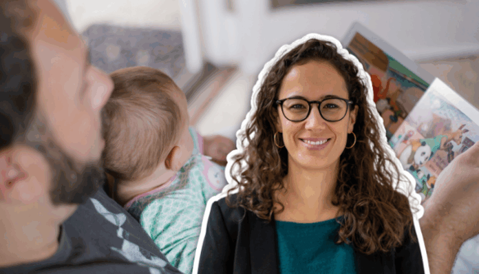 Une femme souriante aux cheveux bouclés et portant des lunettes apparaît en surimpression sur la droite de l’image. À l’arrière-plan, une personne adulte tient un bébé sur ses genoux et lui lit un livre illustré dans une pièce lumineuse.