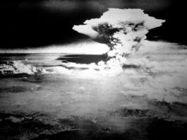 80 ans après Hiroshima et Nagasaki : le monde a besoin d’une interdiction des armes nucléaires Photographie en noir et blanc prise depuis les airs : un vaste nuage en forme de champignon s’élève au-dessus de Hiroshima.