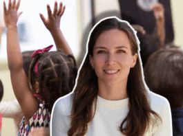 « La crèche : première école de la diversité » — Journal d’une éducatrice #4 Gros plan sur l’arrière d’une rangée d’enfants d’âges préscolaires, assis en classe et levant la main pour répondre à l’enseignant. L’un des enfants, une fillette aux cheveux tressés ornés de perles, porte une robe à motifs colorés. Le portrait d’une femme souriante aux cheveux bruns est superposé.