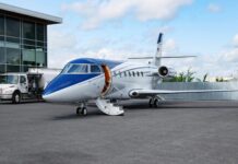 Amsterdam : l’aéroport Schiphol interdit les jets privés à partir de fin 2025 Un jet privé bleu et blanc dans un aérodrome.