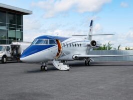 Amsterdam : l’aéroport Schiphol interdit les jets privés à partir de fin 2025 Un jet privé bleu et blanc dans un aérodrome.