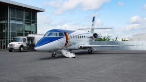 Un jet privé bleu et blanc dans un aérodrome.