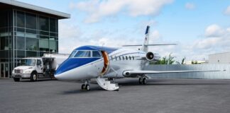 Un jet privé bleu et blanc dans un aérodrome.