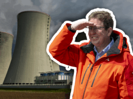 Initiative « Stop au blackout » : la dangereuse politique nucléaire de Rösti Albert Rösti, un homme en veste orange et lunettes se tient devant deux grandes tours de refroidissement d’une centrale électrique, levant la main au front pour regarder au loin sous un ciel gris et menaçant.