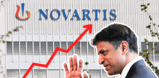 Montage photographique : en arrière-plan, la façade d’un immeuble gris clair arbore en grand le logo et le nom « NOVARTIS ». En surimpression, une flèche rouge zigzaguant de l’angle inférieur gauche vers l’angle supérieur droit symbolise une forte progression. Au premier plan, sur la droite, un homme en costume sombre, de profil, lève la main comme pour saluer.