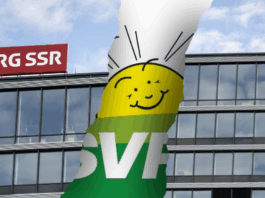 Initiative anti-SSR : l’UDC s’inspire d’une stratégie internationale pour démanteler les médias publics Photomontage montrant la façade vitrée du siège de la SSR avec son logo rouge “SRG SSR”, traversée d’une large déchirure verticale qui laisse apparaître en arrière-plan une bannière verte à l’effigie de l’UDC, ornée d’un soleil stylisé souriant.