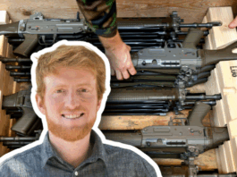 Loi sur le matériel de guerre : « Plus il y a d’armes en circulation, plus le danger pour les civil-es augmente » Portrait détouré en médaillon d’un homme roux souriant, chemise à carreaux, superposé sur l’image d’arrière-plan montrant plusieurs fusils d’assaut empilés dans des caisses en bois, deux mains en uniforme les ajustant.