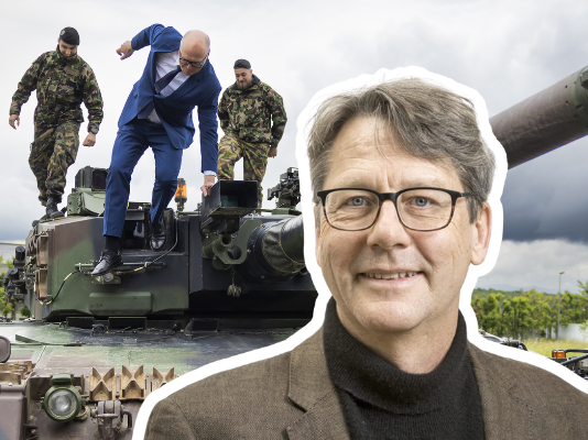 Financement de l’armée : « La politique de sécurité globale passe à la trappe » Image composite : au premier plan à droite, Andreas Missbach, un homme d’âge moyen porte des lunettes, un col roulé noir et une veste marron, il sourit directement vers l’objectif. En arrière-plan, sous un ciel nuageux, on aperçoit un char d’assaut sur lequel deux soldats en tenue de camouflage encadrent Martin Pfister, un homme en costume bleu, cravate sombre et chaussures noires, en train de monter sur la tourelle.