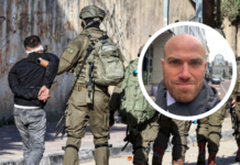 Israël : La peine de mort contre des Palestinien-nes sans procès équitable À l'arrière-plan, des militaires israéliens équipés de gilets tactiques et d'armes encadrent une personne en veste noire, mains attachées dans le dos, face à un mur couvert de graffitis. En superposition, un médaillon circulaire présente le portrait d'un homme d'âge moyen, chauve, avec une barbe courte, photographié dans un environnement urbain.