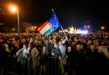 Bonnes nouvelles en avril : Orbán destitué, la LAFE rejetée à Fribourg, la forêt amazonienne est résiliente, le 142 enfin disponible Rassemblement nocturne de milliers de personnes devant le Parlement hongrois à Budapest. Au centre, une personne brandit un drapeau hongrois combiné avec le drapeau de l'Union européenne. La foule, éclairée par des lampadaires, se tient derrière des barrières de sécurité. L'édifice du Parlement illuminé en arrière-plan. Manifestation politique contre Viktor Orbán.
