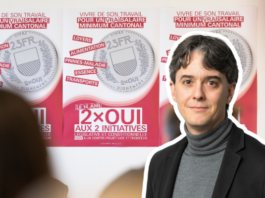 Salaire minimum : « La droite patronale en SManque d’argument » Une personne portant un blazer noir et un col roulé gris se tient devant des affiches de campagne électorale. Les affiches, sur fond rose et blanc, présentent des pièces de monnaie et du texte en français relatif à des initiatives politiques, notamment "2×OUI AUX 2 INITIATIVES". Le message principal porte sur des thèmes sociaux comme le travail, la santé et les allocations familiales, avec mention d'un salaire minimum cantonal.