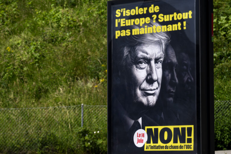 Affiche de campagne contre l'initiative de l'UDC, affichée en plein air, montrant des visages en noir et blanc avec le slogan "S'isoler de l'Europe ? Surtout pas maintenant !" et l'appel à voter NON le 14 juin.
