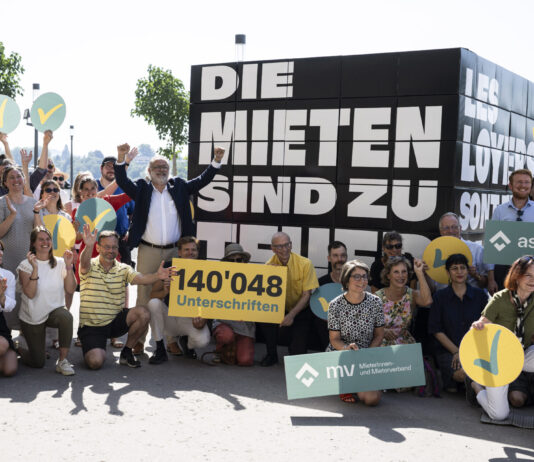 Les loyers sont trop élevés : l’initiative sur les loyers est déposée Manifestation de soutien aux locataires en Suisse. Une foule de manifestants se rassemble devant une grande pancarte noire portant le texte "DIE MIETEN SIND ZU HOCH" (Les loyers sont trop élevés). Au centre, un panneau jaune indique "140'048 Unterschriften" (140 048 signatures). Les participants, dont certains tiennent des symboles jaunes et bleus, posent ensemble pour montrer leur mobilisation contre la crise du logement. Des bannières des organisations "Initiative les loyer" et "asloca" sont visibles, témoignant de l'engagement collectif pour des loyers plus abordables.