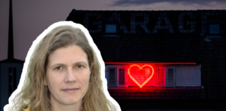 « Les droits des travailleur-euses du sexe sont à nouveau remis en question partout dans le monde » Une femme aux cheveux longs, châtain clair et ondulés, portant une veste sombre et un haut jaune, est représentée en premier plan. En arrière-plan, on distingue un bâtiment à toit sombre sur lequel une enseigne lumineuse rouge en forme de cœur est projetée ou affichée sur une fenêtre à volets. L'atmosphère générale de l'image est sombre, contrastant avec la lumière rouge vive du cœur.