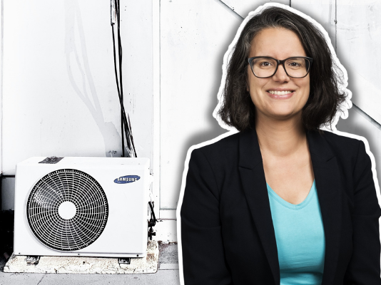 « Poser de la clim ou planter des arbres ? Tel ne devrait pas être le débat » Femme aux cheveux noirs mi-longs, souriant à la caméra avec des lunettes de vue, vêtue d'un blazer noir professionnel sur un haut turquoise, composée sur une image de fond montrant une unité de climatisation Samsung blanche et noire fixée à un mur.