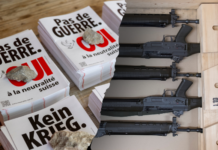 « Pas de guerre » : comment l’UDC trompe l’électorat Collage montrant à gauche des affiches de protestation suisse avec les slogans 'Pas de GUERRE' et 'Kein KRIEG' (Non à la guerre en français et allemand) avec le logo du référendum suisse, et à droite une boîte en bois contenant un arsenal organisé de plusieurs fusils d'assaut noirs alignés horizontalement avec des chargeurs et accessoires tactiques.